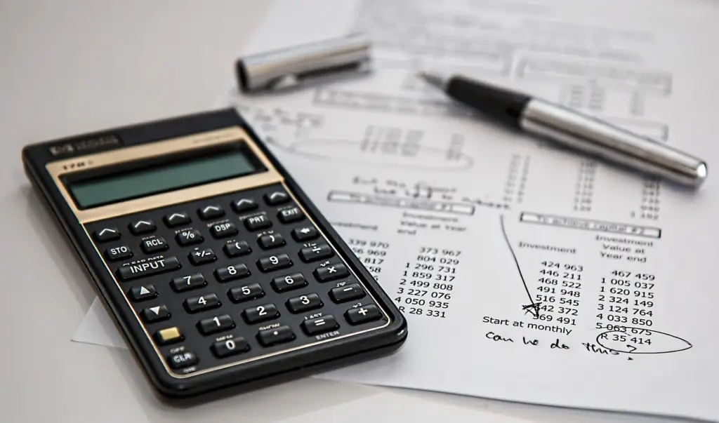 Calculator and pen on desk calculating forex costs